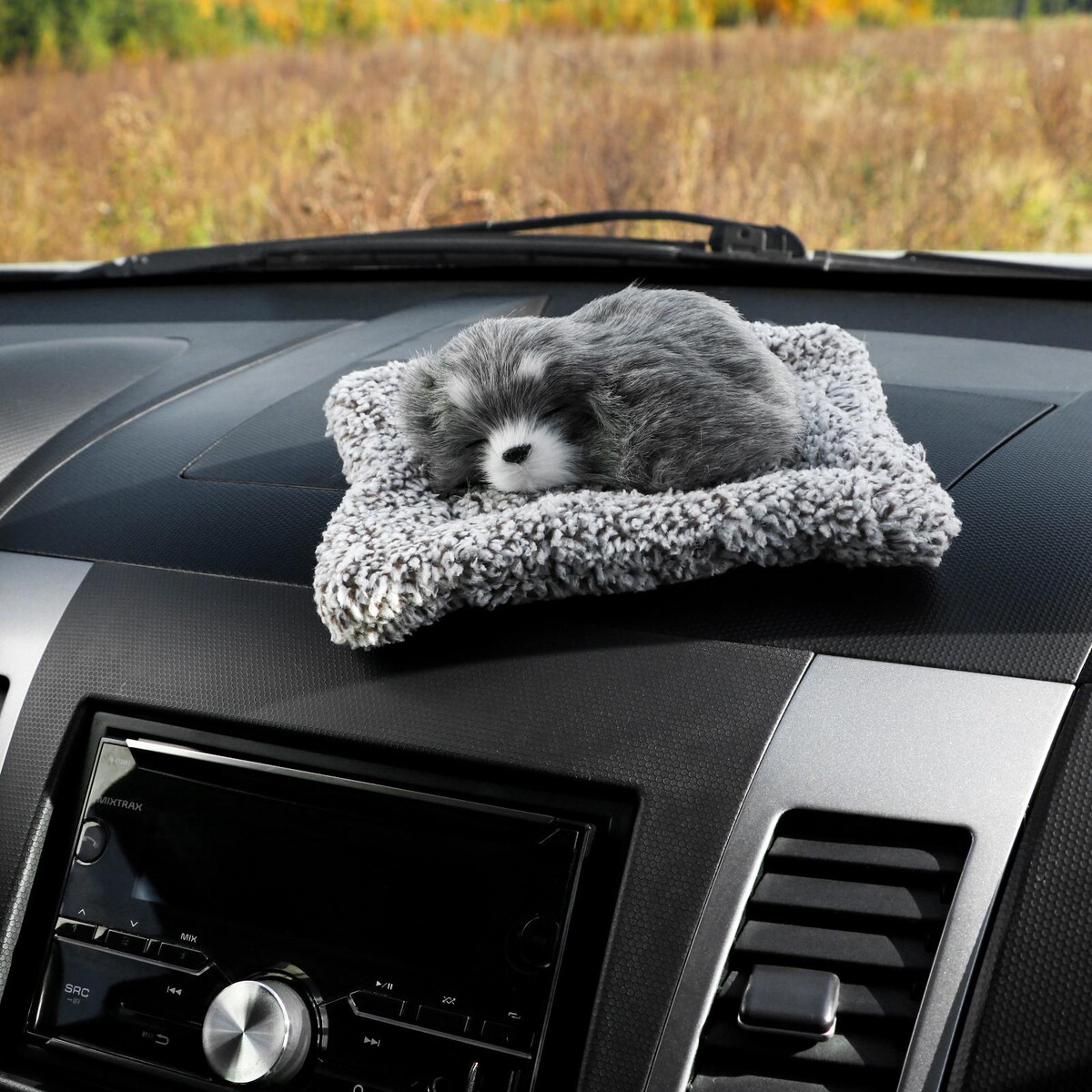 фото Игрушка на панель авто, собака на подушке, серый окрас no brand