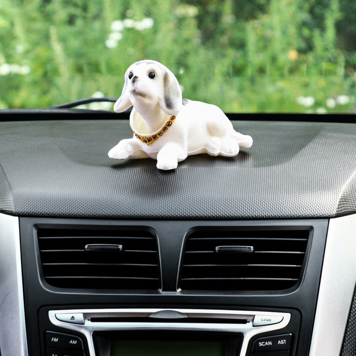 Собака на панель авто, качающая головой, большая, белый окрас фото